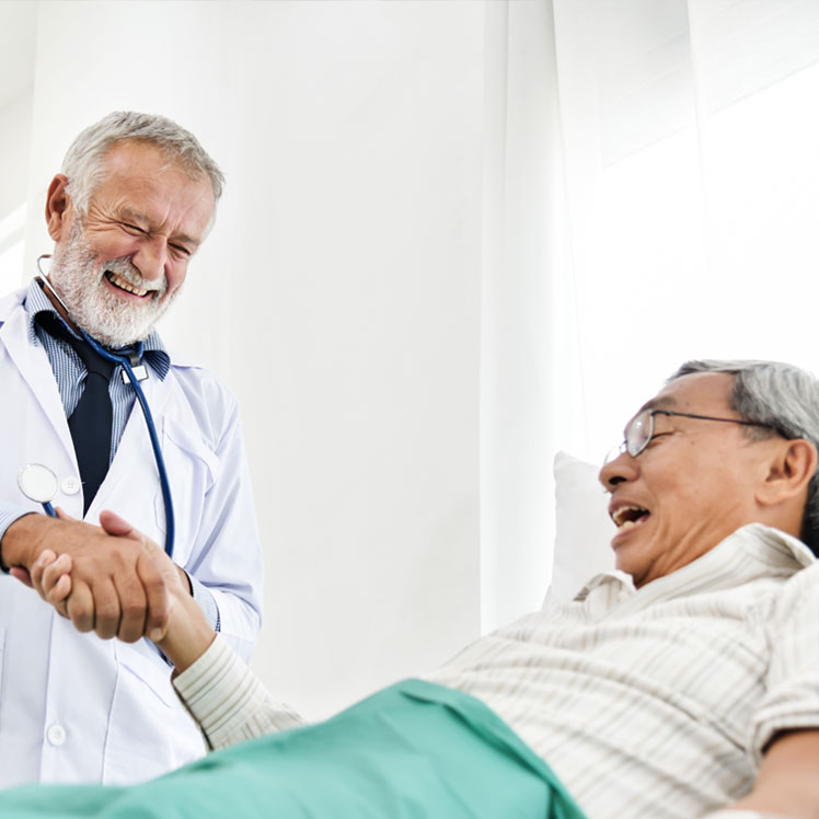Doctor speaking to elderly patient bedside